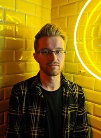 Portrait of young man standing by wall