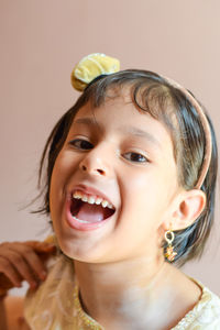 Close-up portrait of cheerful girl wearing headband at home