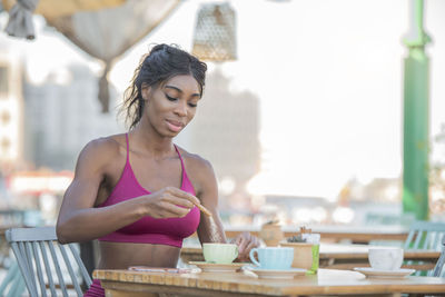 Young woman holding drink at table