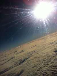 Scenic view of sun shining on landscape against sky