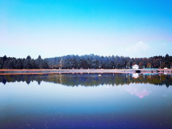 Scenic view of lake against clear blue sky