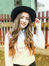 Portrait of smiling young woman in hat