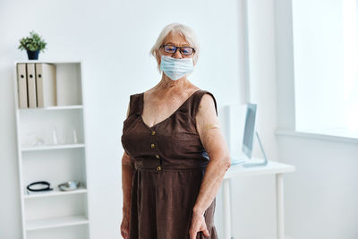 Portrait of a woman standing against wall