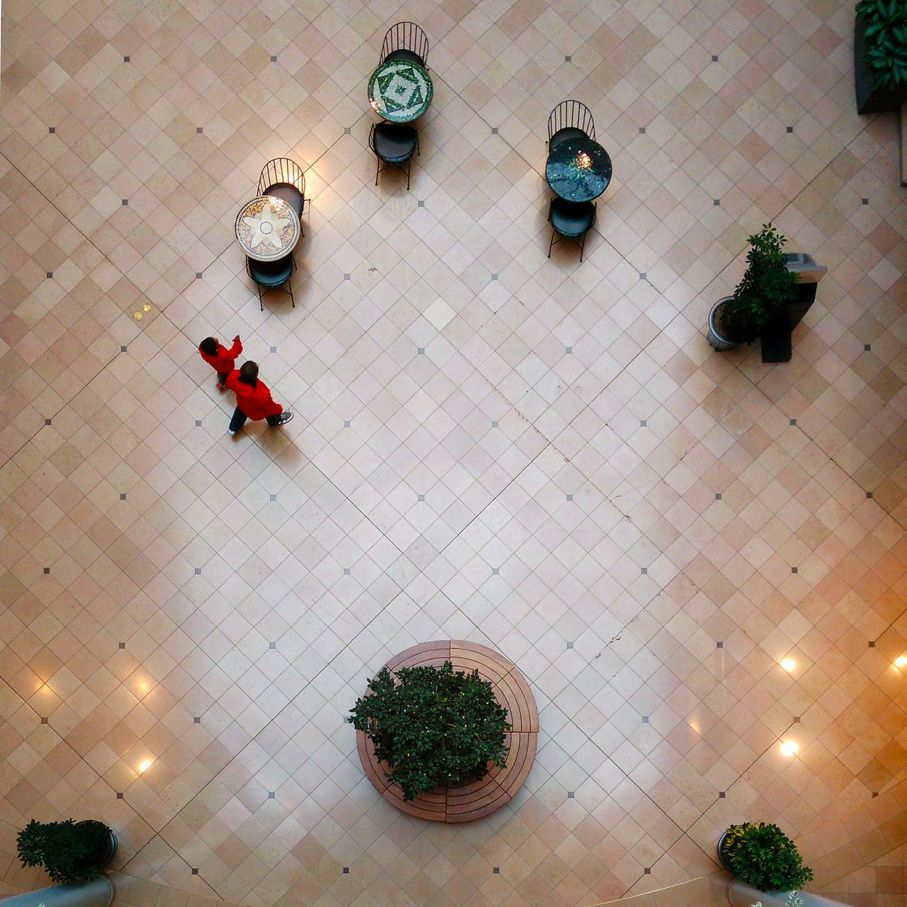 HIGH ANGLE VIEW OF PEOPLE ON TILED FLOOR IN CORRIDOR