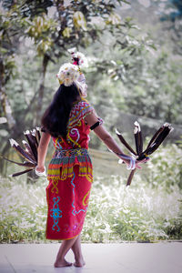 Rear view of woman standing against wall