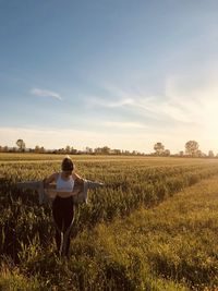 Rear view of woman walking on field
