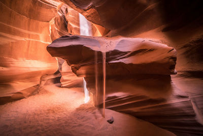 Sand falling from rock formations in cave