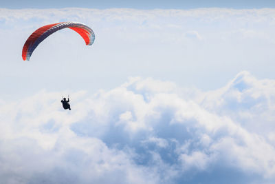 Low angle view of man paragliding in sky