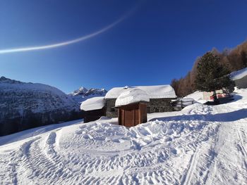 Snow covered field against blue sky