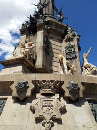 Low angle view of statues on building against sky