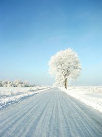 Scenic view of snow covered landscape against clear blue sky