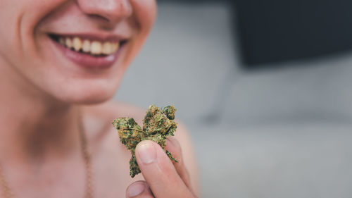 Midsection of smiling young man holding medical cannabis