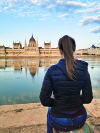 Rear view of woman standing at riverbank