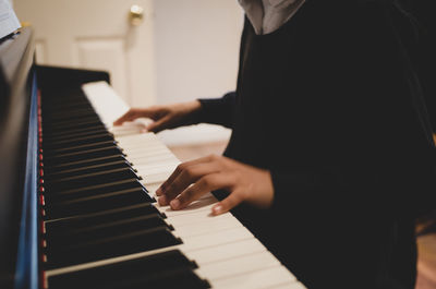 Midsection of man playing piano