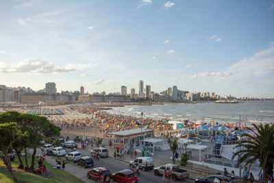 High angle view of city buildings by sea against sky