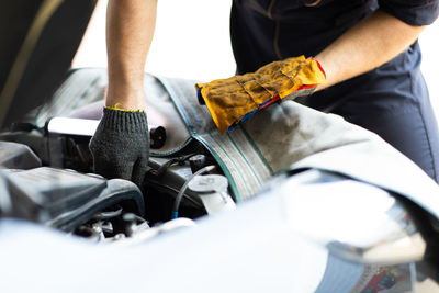 Midsection of man working in car