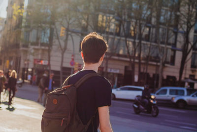 Rear view of man with umbrella in city