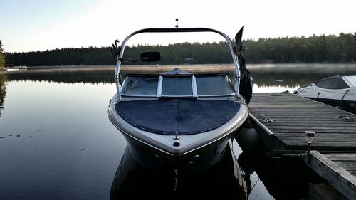 Pier amidst boats moored on calm lake