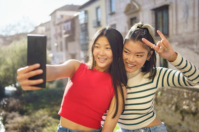 Portrait of smiling young woman standing in city