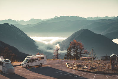 Road by mountains against sky