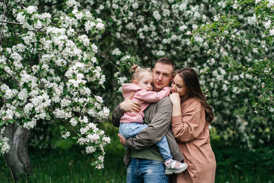 Family mom mom baby daughter in the garden blooming apple trees