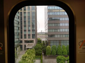 Buildings against clear sky seen through glass window