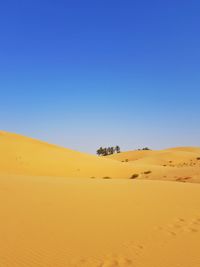 Scenic view of desert against clear blue sky