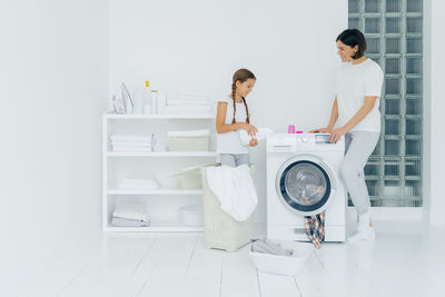 Daughter assisting mother in laundry at home