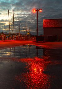 Reflection of illuminated building in puddle at night