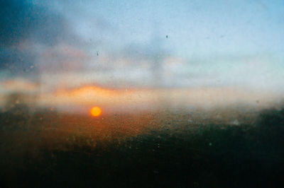Defocused image of wet glass window during sunset