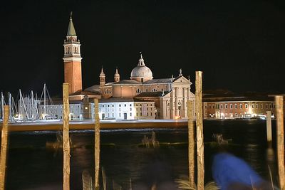 Reflection of church in river against clear sky at night