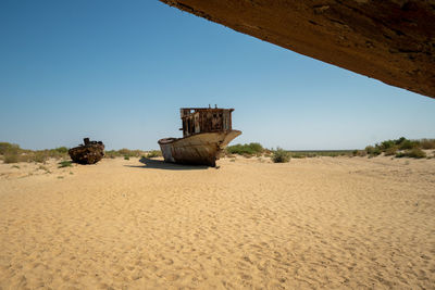 Built structure on desert land against clear blue sky