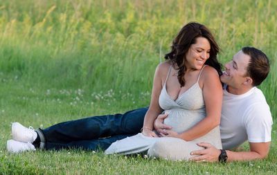 Happy mother and daughter sitting on grass