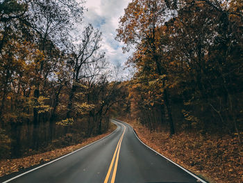 Road amidst trees during autumn