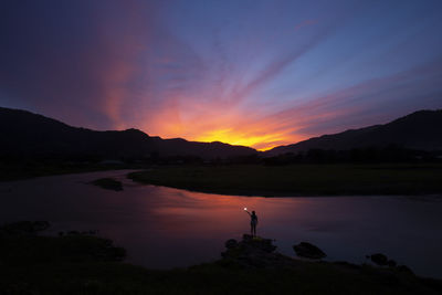 Evening landscape, rivers, mountains, dark blue sky, beautiful clouds, shadows of people 