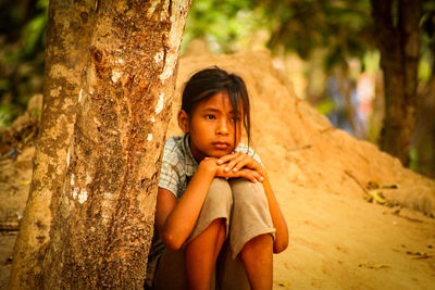 Close-up of girl against tree during sunset