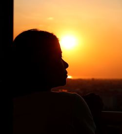 Portrait of silhouette man standing against orange sky