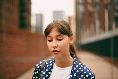 Portrait of teenage girl standing in city