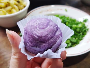 Close-up of hand holding ice cream in plate