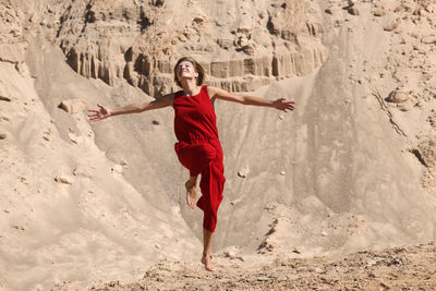 Full length of woman with arms raised