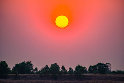 Scenic view of field against orange sky