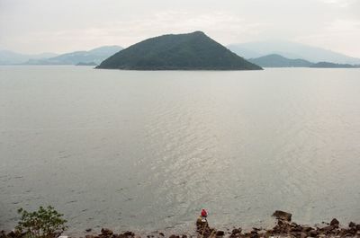 Scenic view of sea and mountains against sky