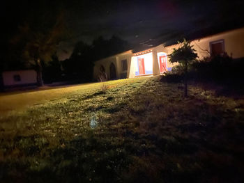 House on field against sky at night