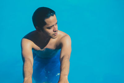 Close-up of shirtless man standing in swimming pool