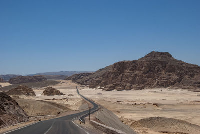 Scenic view of desert against clear blue sky