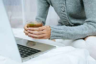 Midsection of woman using laptop