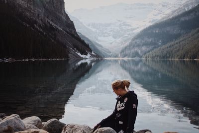 Side view of young woman standing in lake during winter