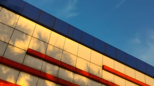 Low angle view of modern building against blue sky