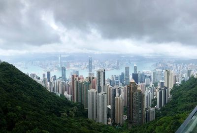 Aerial view of modern buildings against cloudy sky in city