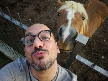 Portrait of mature man taking selfie with horse